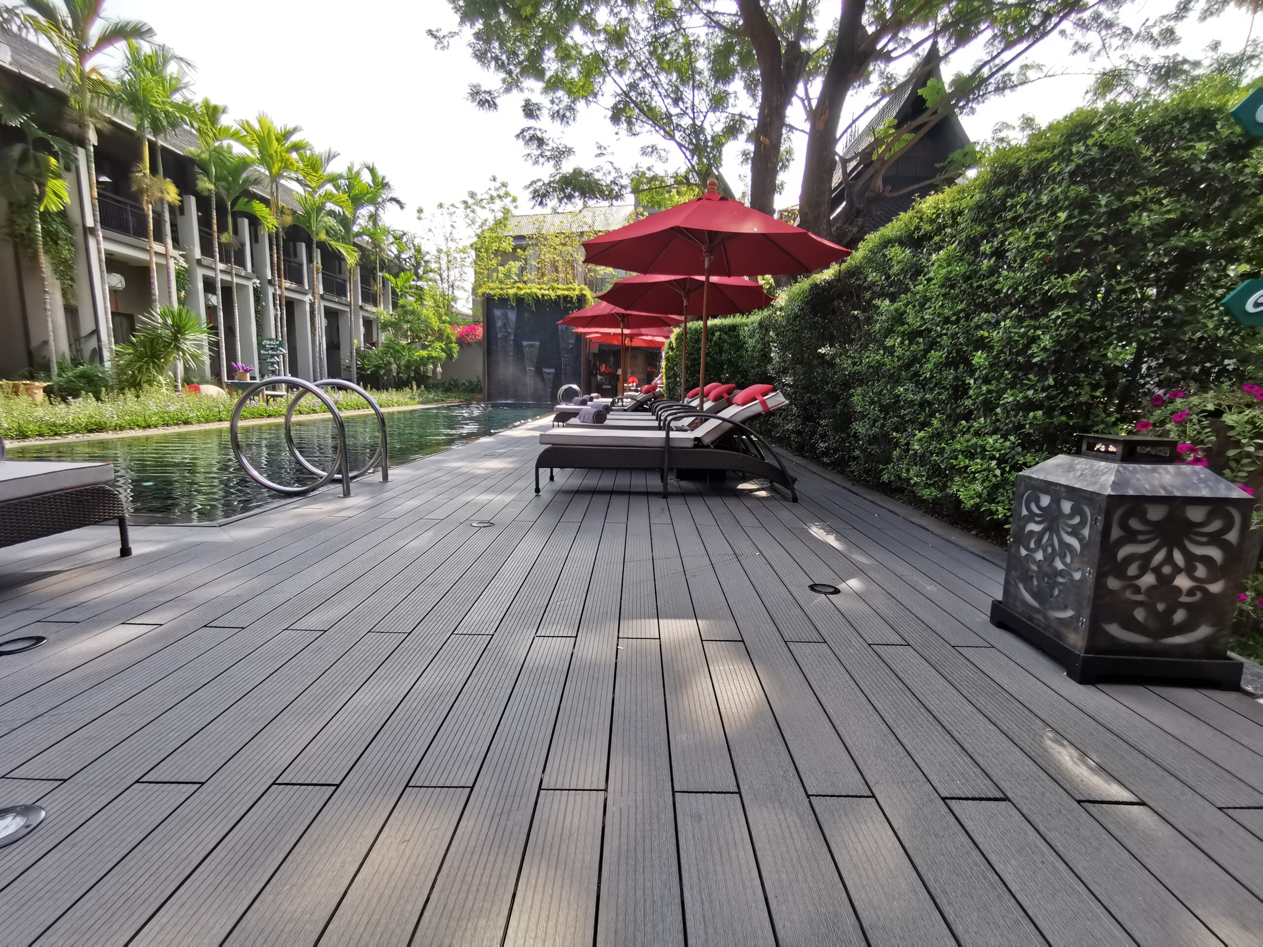 พื้นไม้ WPC สีเทาเข้ม ติดตั้งรอบสระว่ายน้ำในโรงแรมหรู ทนทานต่อความชื้นและกันลื่น